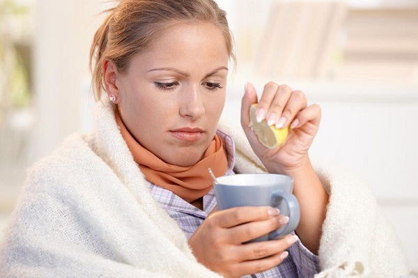 Девушка пьет чай с лимоном от простуды