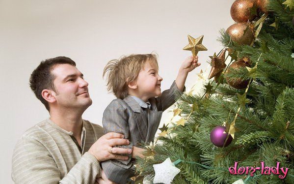 Ребенок с папой наряжают елку